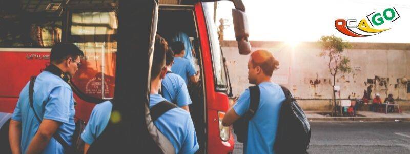 Група людей заходить в червоний автобус